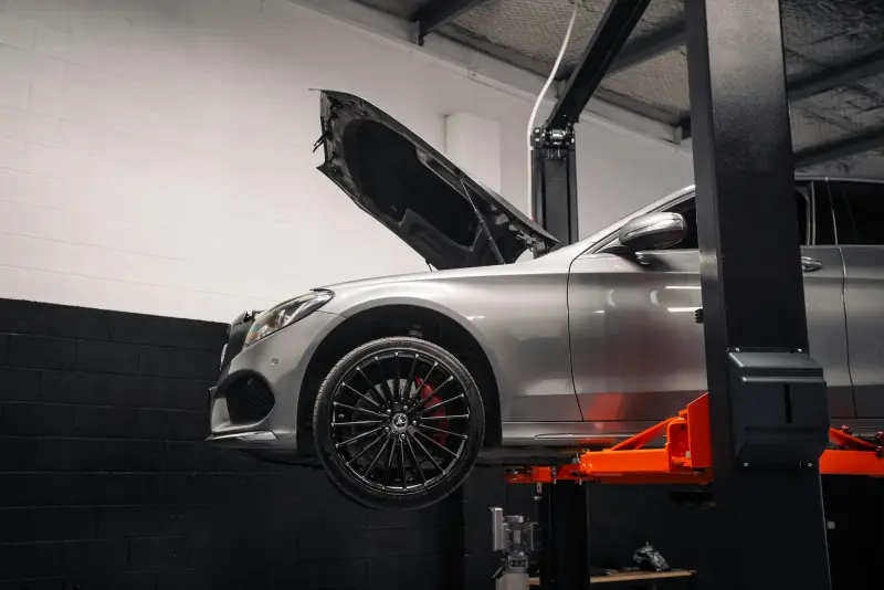A car on a vehicle lift in a clean workshop